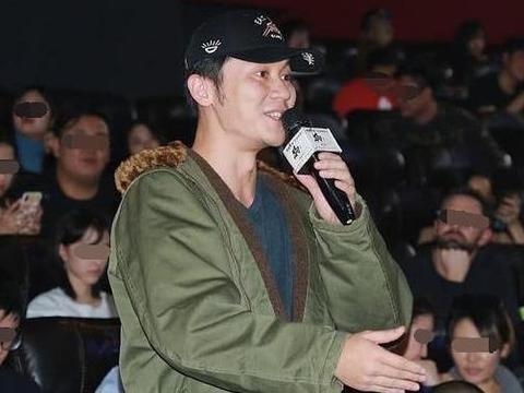 李晨近照曝光,穿绿色棉大衣戴鸭舌帽,手拿话筒起身发言