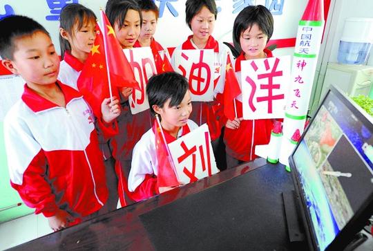 16日，河南新蔡凯旋双语实验学校的留守儿童在观看神九发射网络视频直播。新华社发