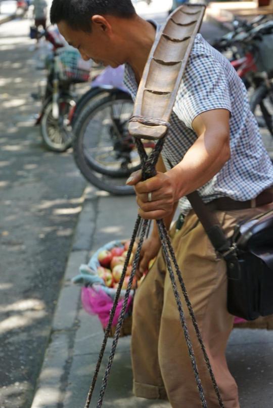 见停下没有生意,他便又忍不住站起来挑着水果继续边走边沿街叫卖.