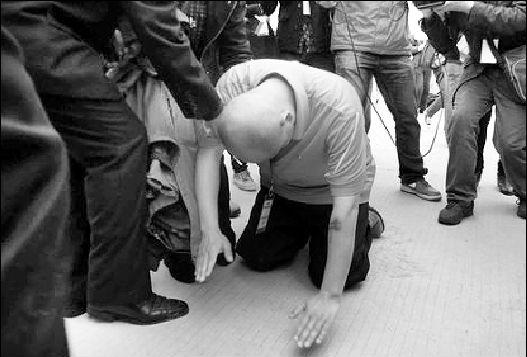 一名民间组织人士参观完"活熊取胆"后,在养殖场向黑熊跪拜谢罪.