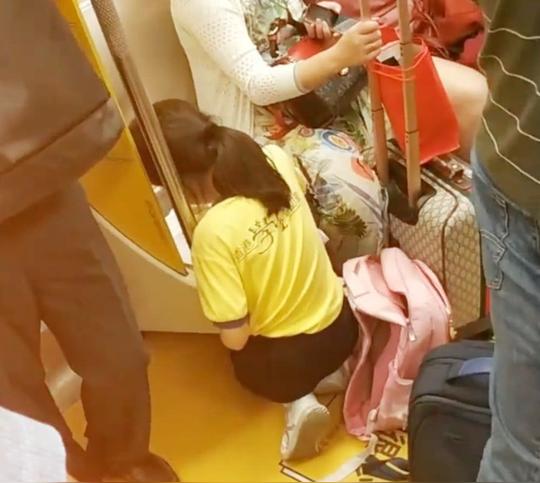实拍地铁一幕,小女孩跪在地地上写作业,网友:家教太好