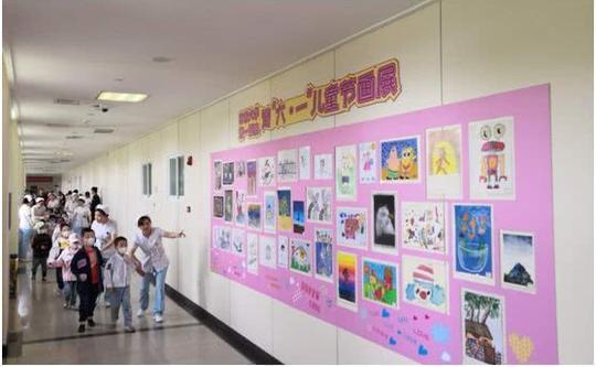 孩子们在医护人员的陪伴下穿过画廊来到活动场地