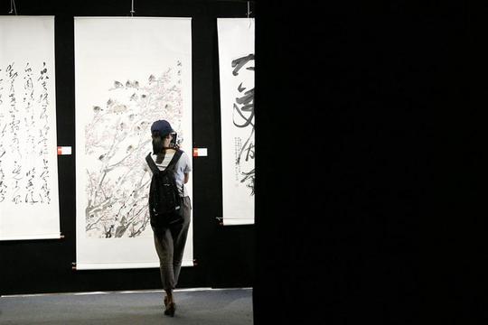 span>一位女游客在门道中国展览的书画作品前拍照/span>