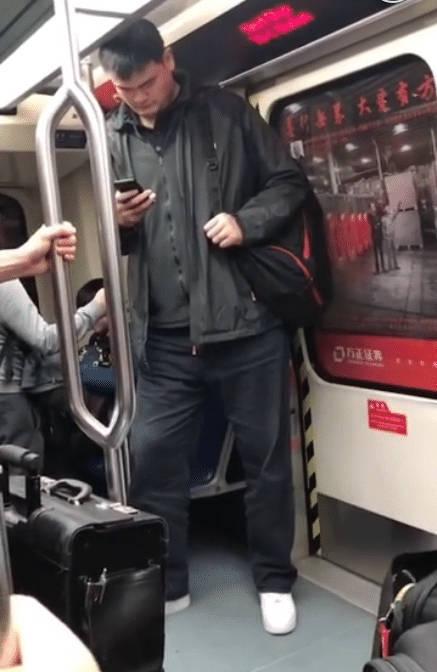 身高太高也是烦恼！姚明低调坐地铁，抬不起头只能假装低头玩手机