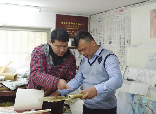 严黎声(右)正在走访书画装裱技艺非遗创业者周斌,了解他在创业过程中