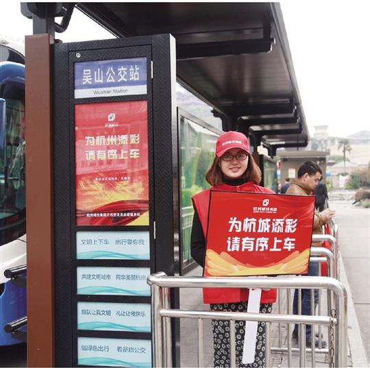 在吴山公交站,城投集团志愿者在文明劝导