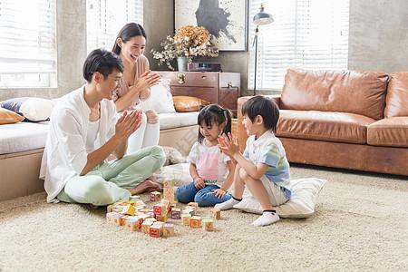 年轻父母陪孩子在家玩游戏图片下载