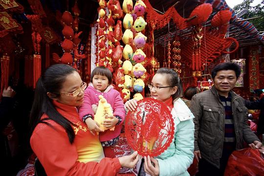 1月21日，市民在南宁市交易场附近的摊位上选购春节饰品。