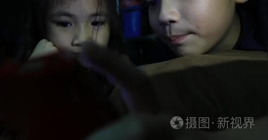 亚洲家庭父亲女儿和儿子观看视频从平板电脑短视频