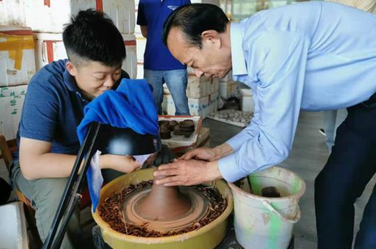 梁先才示范陶器制作。华龙网-新重庆客户端王钰摄