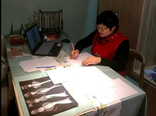 图为残疾人自主创业典型正在进行服装设计