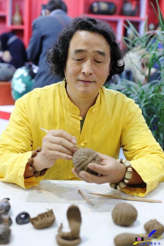 德州先利黑陶研究所所长王宪利在现场演示黑陶核桃的制作