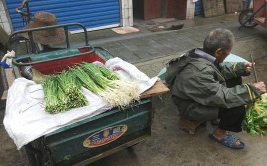 农村八旬老人摆摊卖菜,阴雨中摆摊却不为挣钱,真相令人心酸