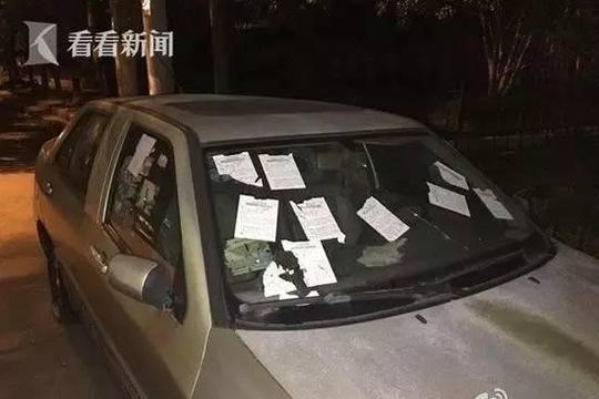 一辆沪牌小汽车,前挡风玻璃,前面两扇车窗上满满全是罚单啊!