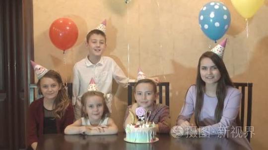 孩子们在家里过生日。过生日的男孩和他的朋友笑和开心