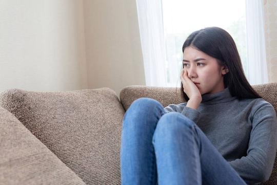 独自坐在沙发上的不开心的亚洲漂亮年轻女子_539273501