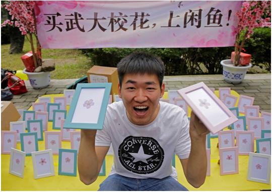 (图为武汉大学毕业集市上,摊主向记者展示自己的"校花"生意)