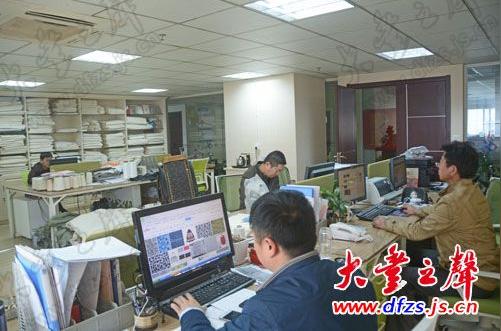 大丰渤海商品员工正在进行网上交易平台与客户洽谈布料生意.