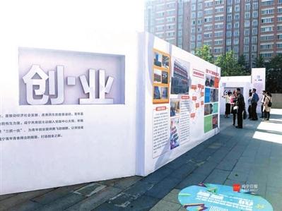 市青少年宫门前的咸宁共青团服务青年创新创业成果展展板吸引市民参观