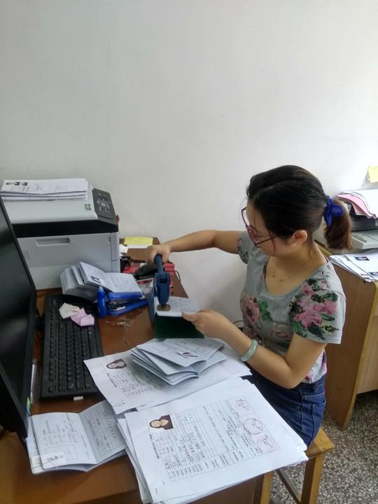 图为区人社局工作人员在为新增就业人员办理《就业失业登记证》