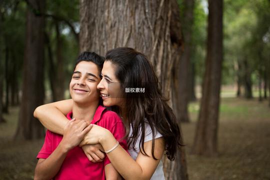 亲爱的拉丁母亲拥抱青少年的儿子和微笑