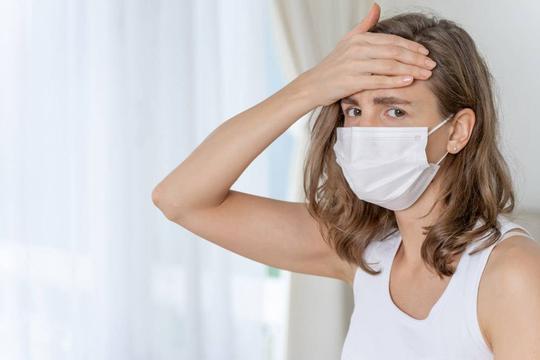 女人穿着面罩保护感觉病人的头疼和咳嗽因为_11993818