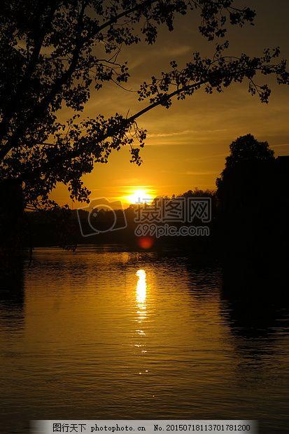 夕阳下静谧的湖面日落河多瑙河水树路太阳晚上背光