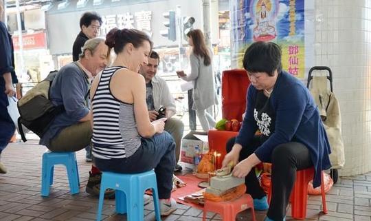 香港铜锣湾桥下每年的打小人改成打疫情，生意异常火爆