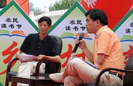 残疾人周华(右)讲述他身残志不残,艰苦奋斗创业的故事.