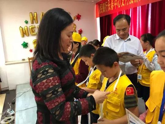 人民银行长春中心支行币金银处调拨科科长王莹为小记者颁发胸牌