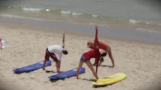高清模糊散景拍摄海边沙滩夏天教授年轻人瑜伽动作实拍视频素材