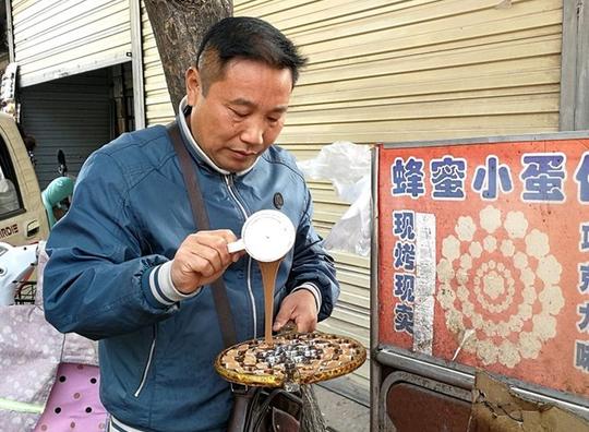 图为正在做小面包的农村大哥,每天在学校门口摆摊做生意.