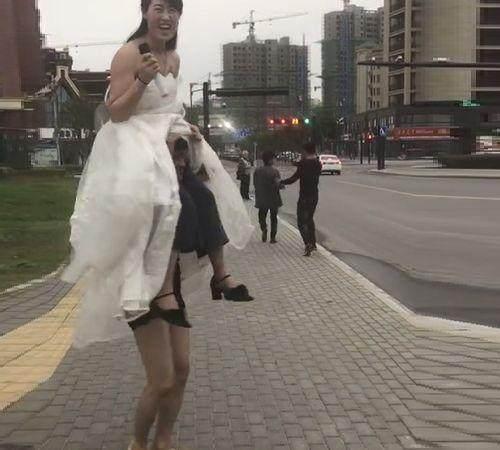 街头惊现两米高女巨人卖唱，吸引不少路人眼光，结果被人当众拆穿
