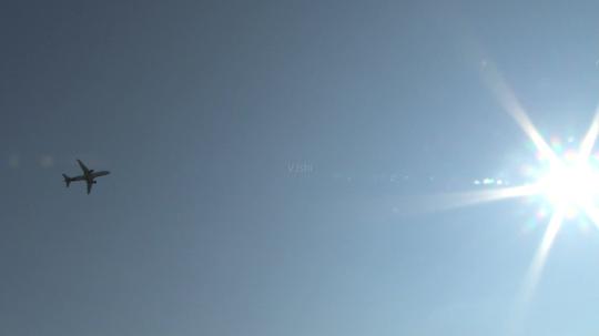 仰拍空中飞机飞行飞过太阳_1920x1080_高清视频素材