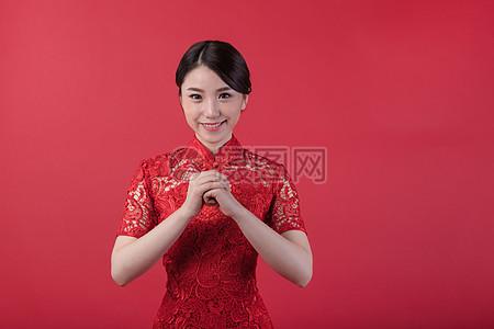 新春身着旗袍的美女拜年高清图片