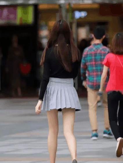 街拍:穿百褶短裙的美女修长美腿展示优美曲线，引路人侧目