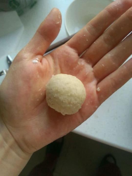 右手手指沾水，用鱼蓉包裹芝士。然后右手手心沾水，把鱼丸在两手心间来回倒，使其圆润好看。