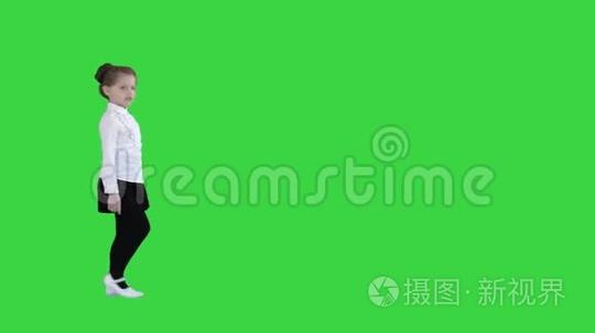 可爱的快乐女孩在绿色屏幕上唱成想象中的麦克风，色度键。短视频