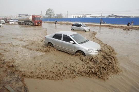郑州路面不下雨也积水捞车牌成生意(2)