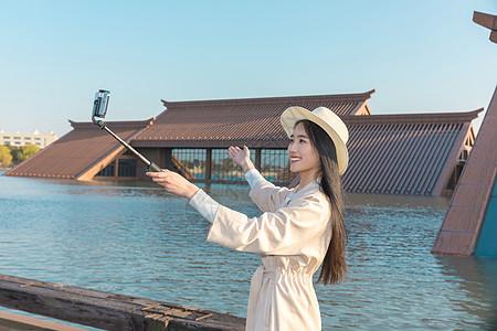 美女大学生春游拿自拍杆拍照图片下载