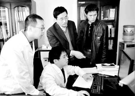 刘纪平(右二)与技术人员一起攻克技术难关