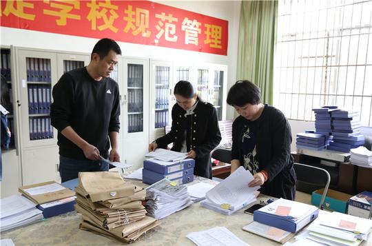 图:杨庆庆副校长(右一)认真查看支撑佐证材料