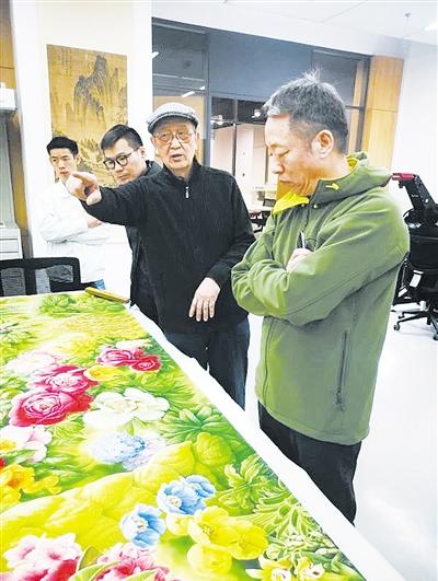 ◀导演李成才(右)与植物画家曾孝濂(右二)一起讨论纪录片同名画作。