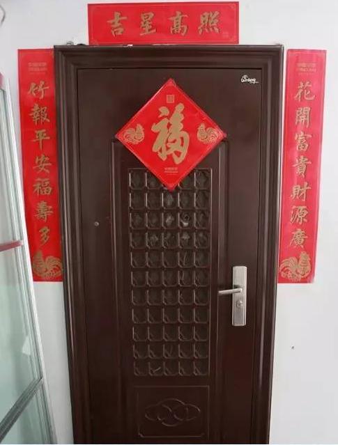 与501残破的门面相反,502的住户张贴了对联,还在门上安装了一个监控.