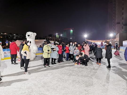 家长带着孩子参加冰雪运动会。