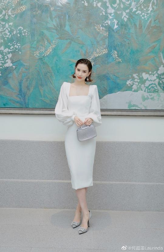 4/6新浪娱乐讯2021年11月5日晚，何超莲微博晒出一组活动写真。她穿白色低胸晚礼服配闪亮鞋包流光溢彩，黑白经典影调彰显豪门气场。