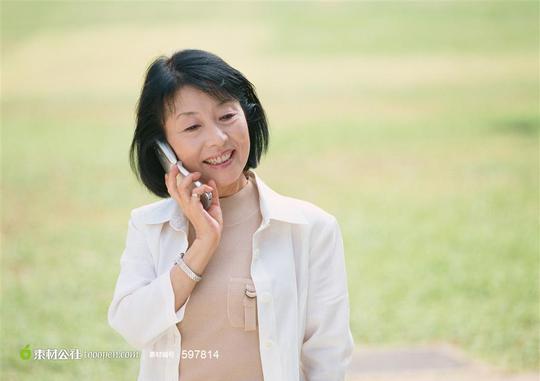 接电话微笑的女性老人摄影素材