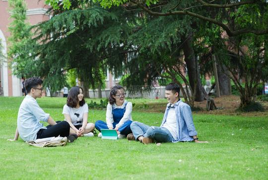 男女大学生们坐草地上聊天休息图片下载