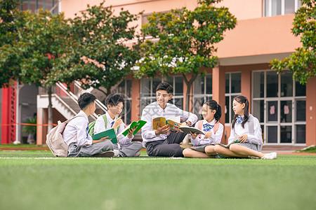 老师和学生坐在操场上讨论图片下载