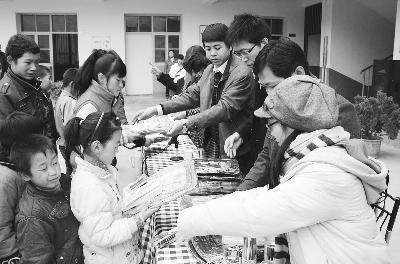 图片新闻:志愿者正在为聋哑儿童分发慰问品